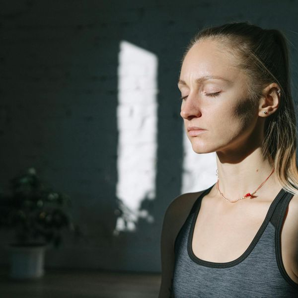 A person smiling peacefully with closed eyes, feeling a sense of well-being and inner balance.